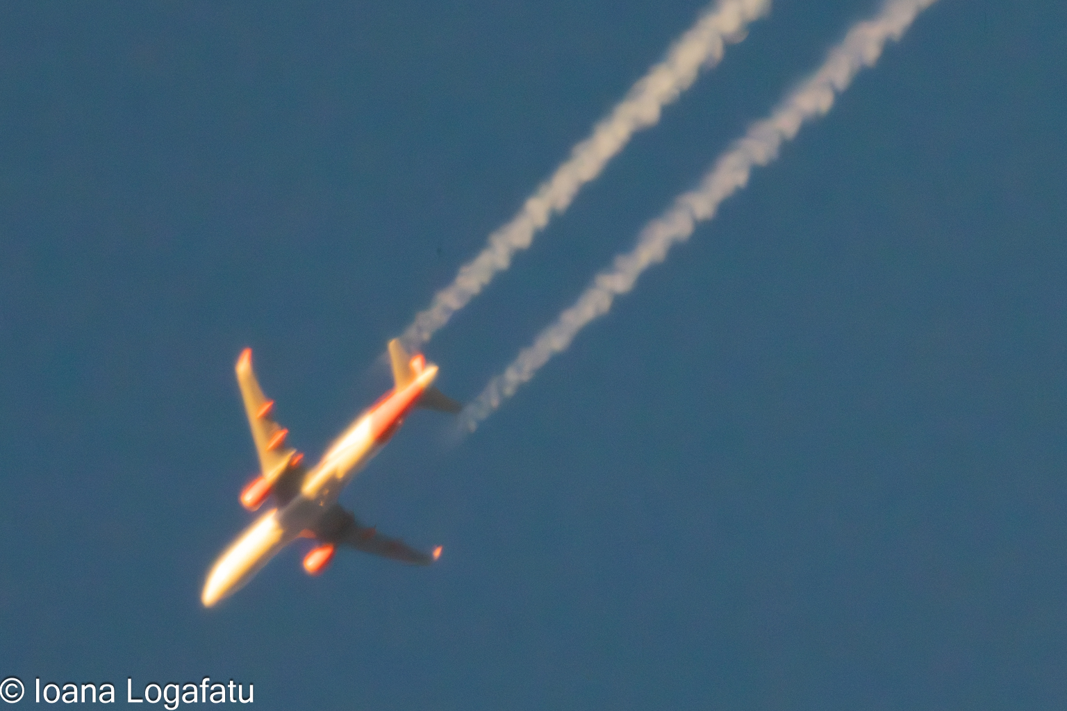 Jet flying through clear sky with contrails